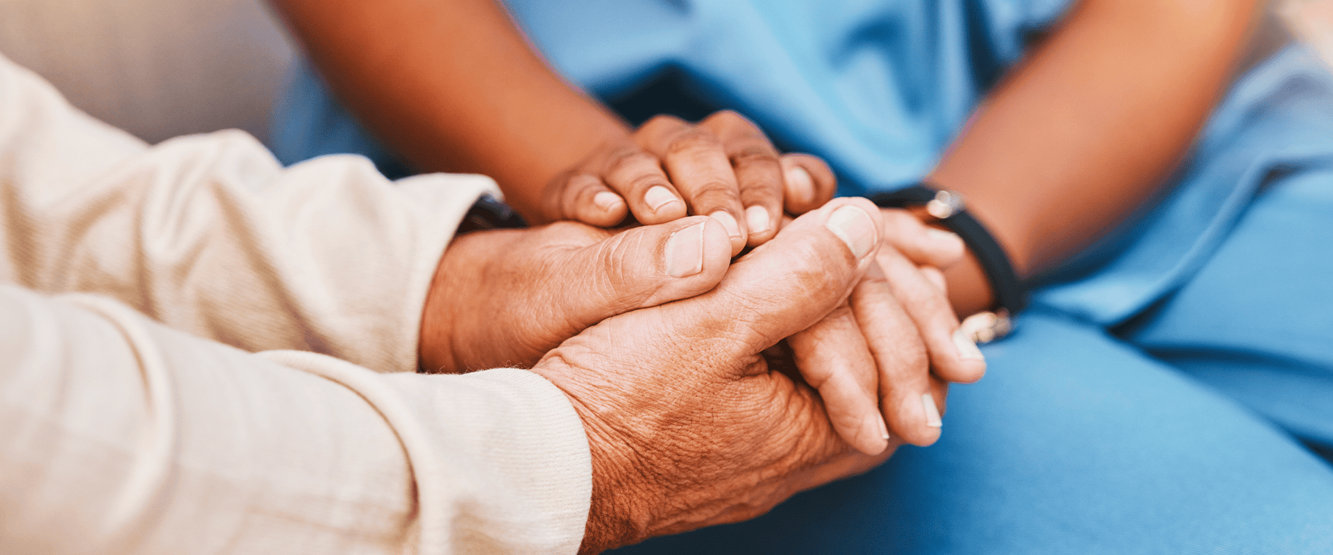 Soignante tenant la main d'un senior – Ziédou, votre téléassistance locale